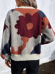 Abstract floral knit sweater with round neck in burgundy, orange, blue, and green tones.