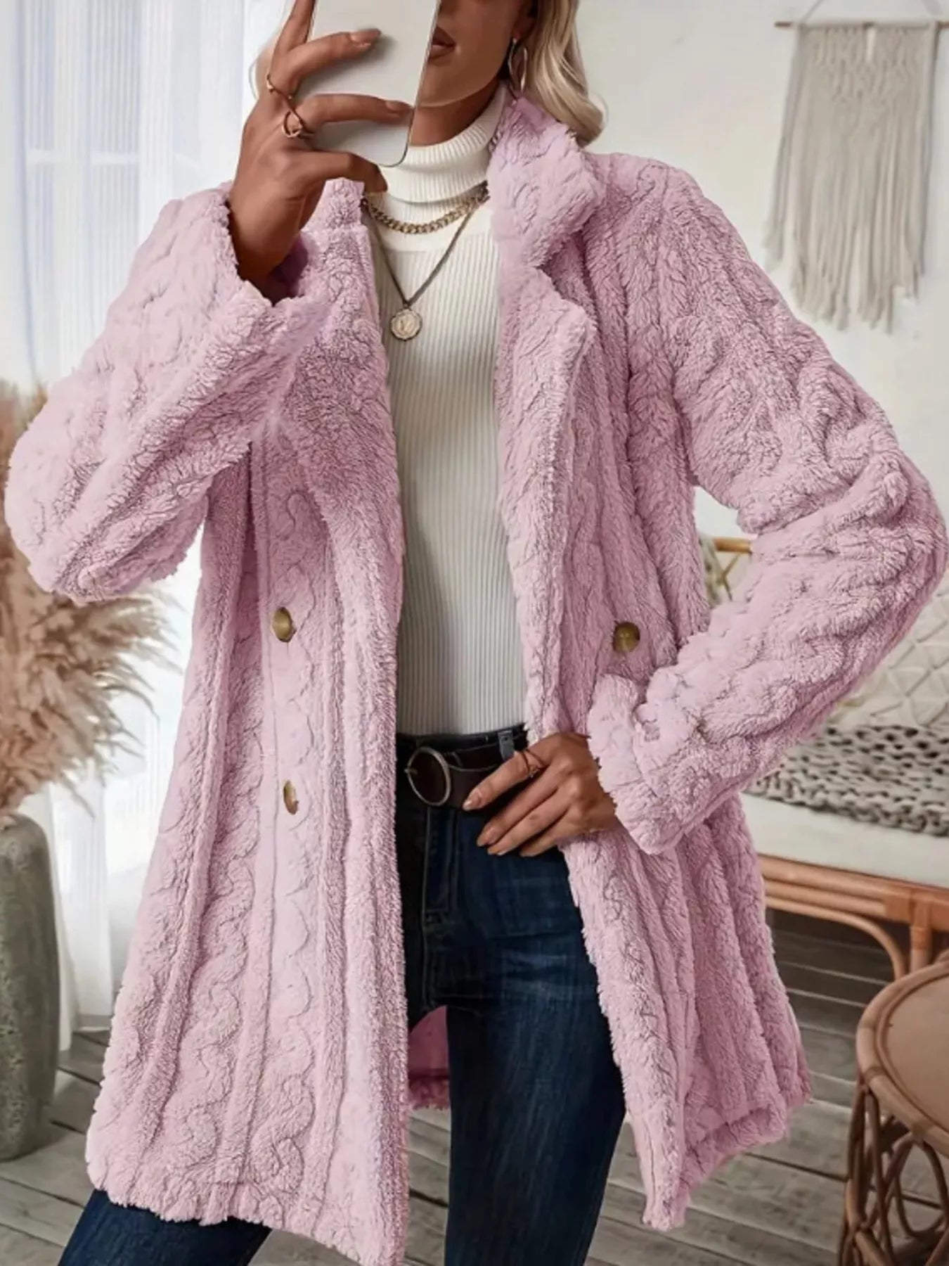 Pink faux shearling double-breasted overcoat with cable knit texture and button closure.