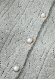 Gray lace-effect knit button-down cardigan with pearl buttons and diamond pattern.