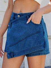 Light blue denim skort with wrap-effect and angled seams, featuring pockets.