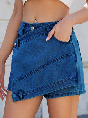 Light blue denim skort with wrap-effect and angled seams, featuring pockets.