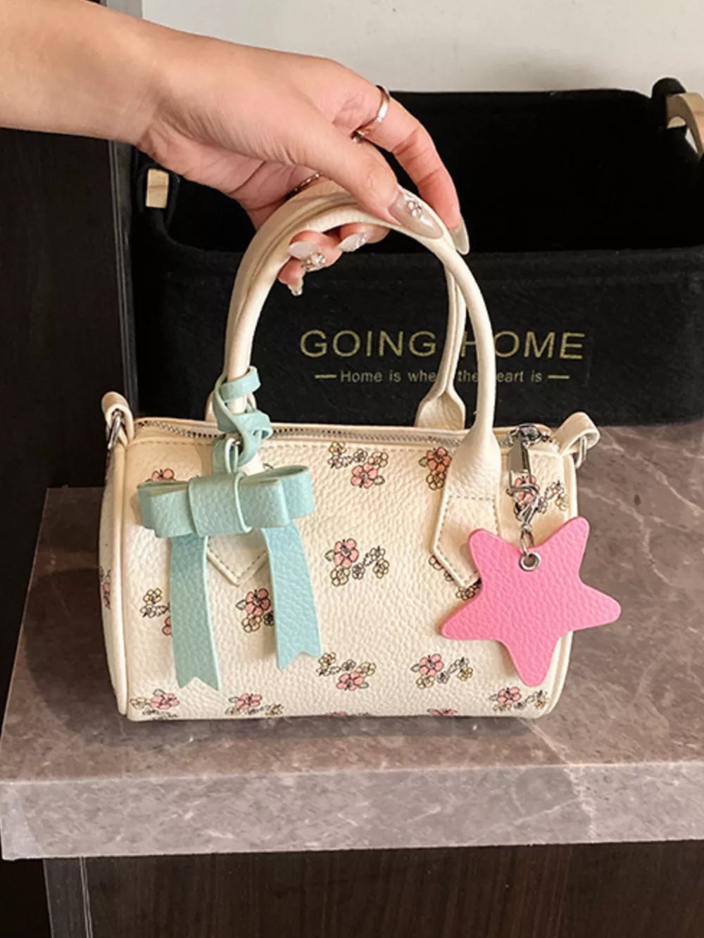 Charming floral mini crossbody bag in cream with pink flowers, blue bow, and pink star charm.