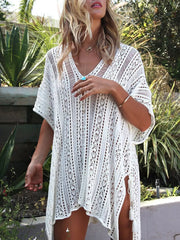 White crochet V-neck beach cover-up with intricate cutout pattern and side slits with tassels.