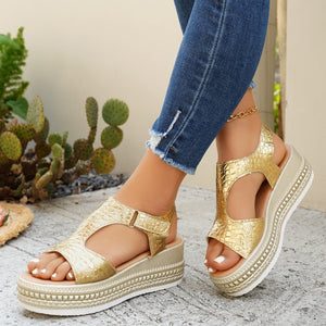 Gold crocodile-embossed platform sandals with adjustable buckle detail.