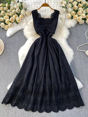 Black eyelet maxi dress with cutout detail and scalloped hem.