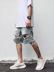 Men's distressed denim shorts in blue with ripped details and frayed hem.