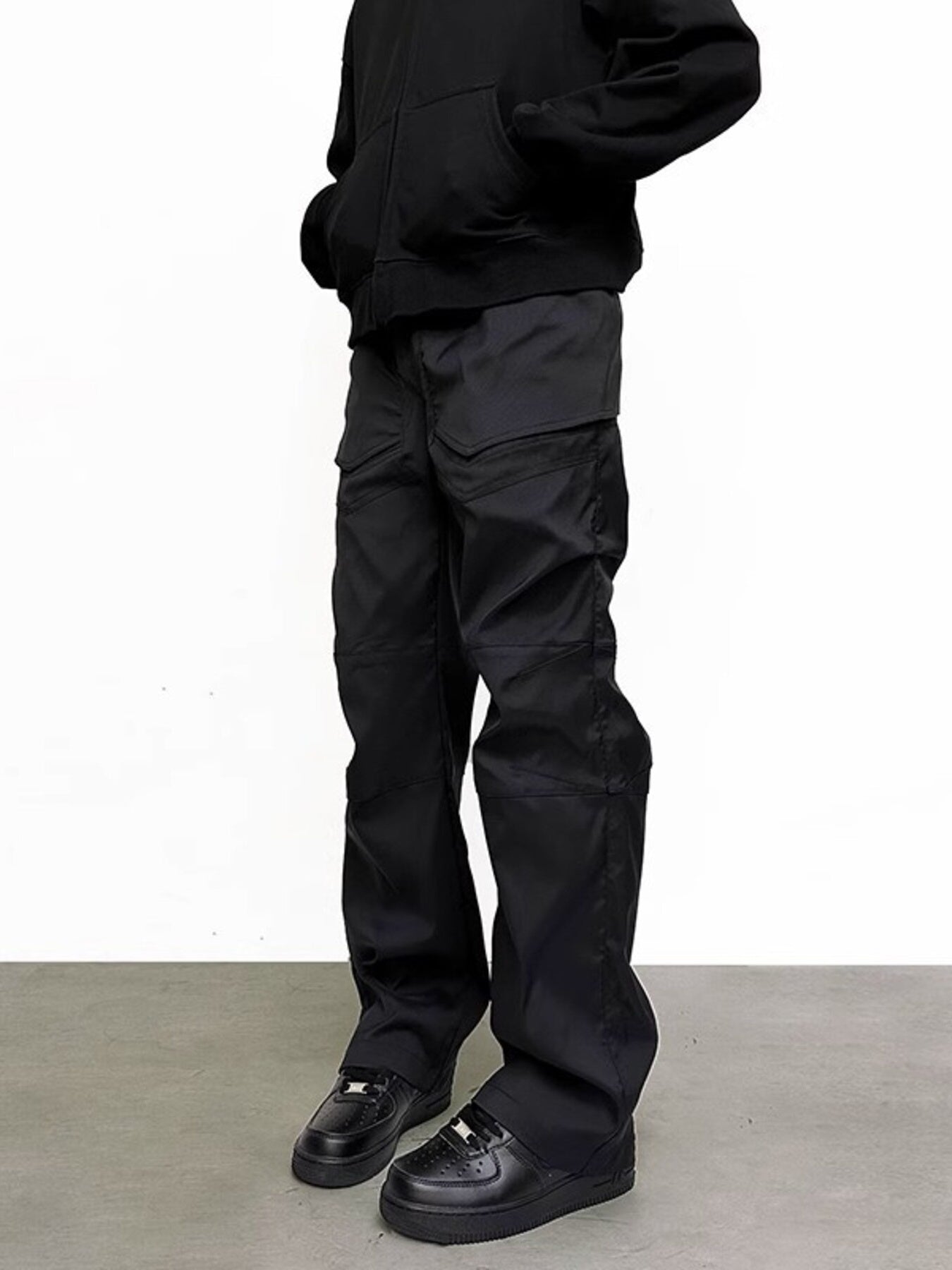 Men's black pocketed sweatpants with a relaxed fit and cargo-style pockets.