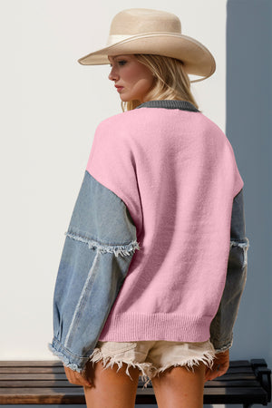 Pink knit sweater with denim sleeves and frayed cuffs, crew neck.