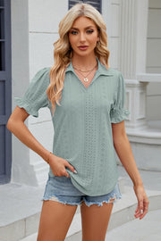 Light green eyelet polo blouse with smocked puff sleeves and a v-neck.