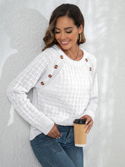 White crewneck knit sweater with textured pattern and button details on the shoulder.