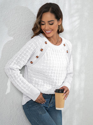 White crewneck knit sweater with textured pattern and button details on the shoulder.