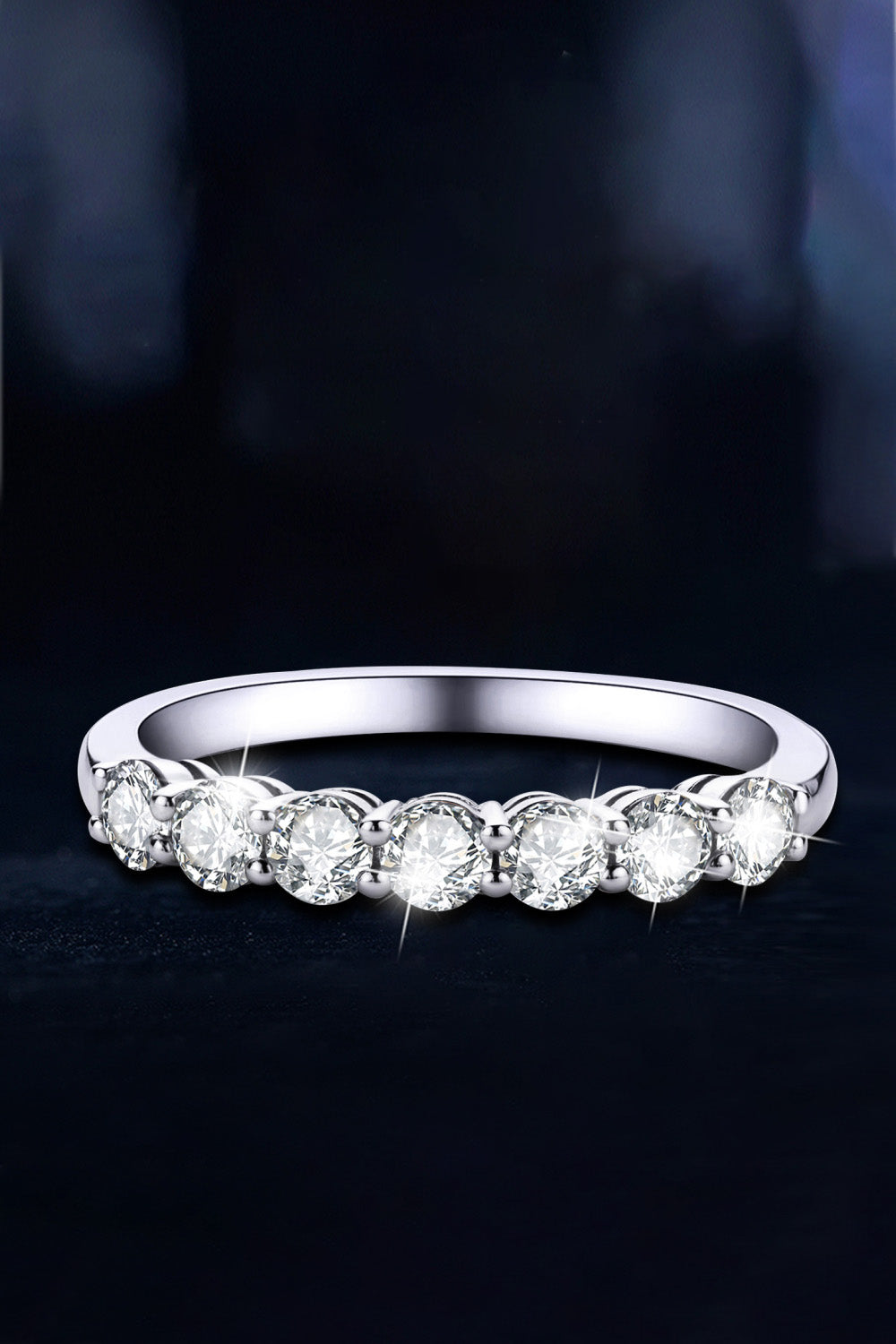 Silver band ring with seven round-cut moissanite stones.