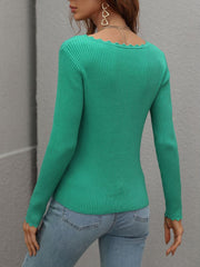 Green ribbed knit top with scalloped edges and long sleeves.