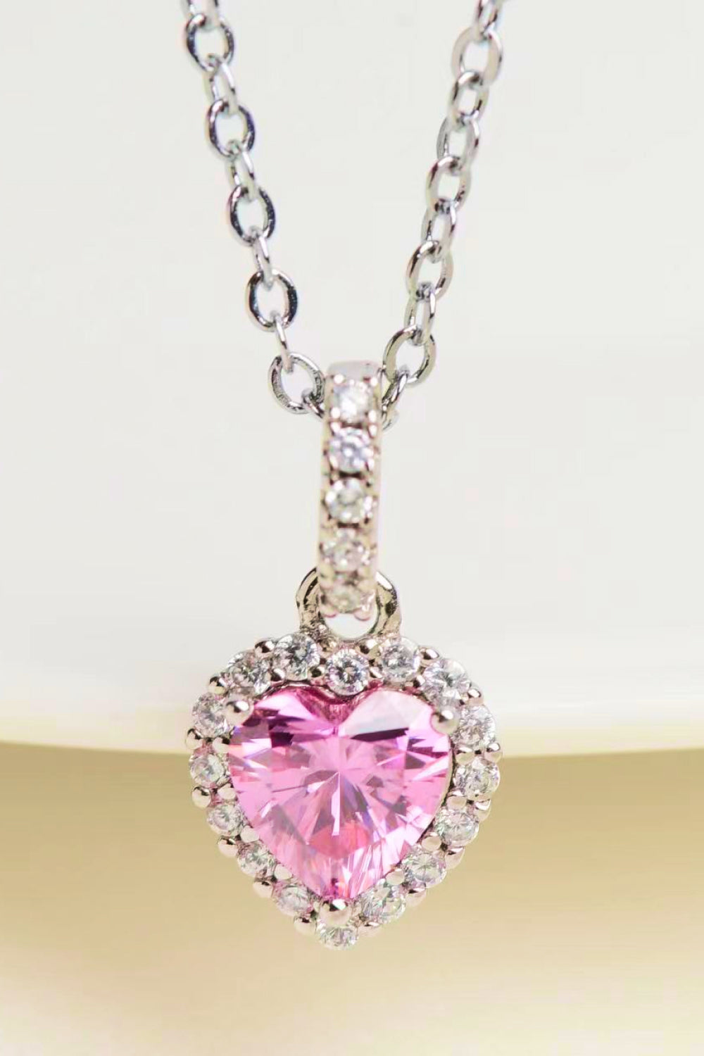 Pink heart halo pendant necklace in 925 sterling silver with clear cubic zirconia accents.