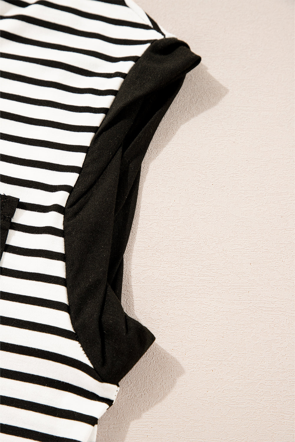 Black and white striped t-shirt with black sleeves and a pocket detail.