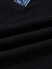 Black textured knit polo top with denim trim detail