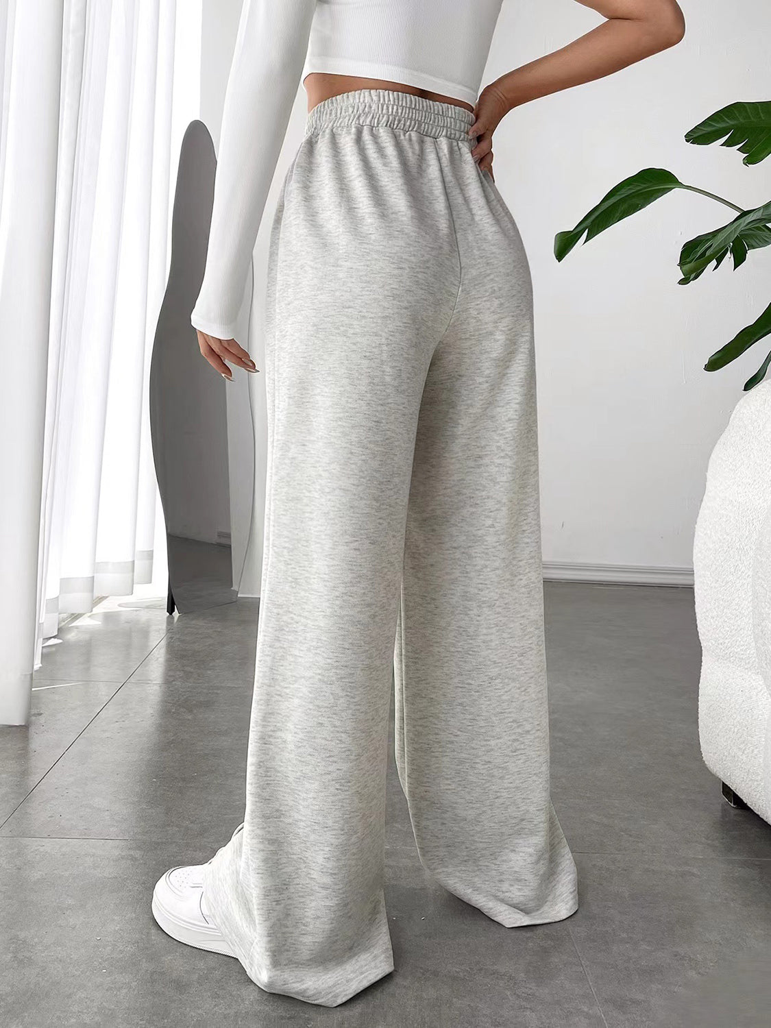 Light gray sweatpants with V-waistline and center seams, wide leg palazzo cut.