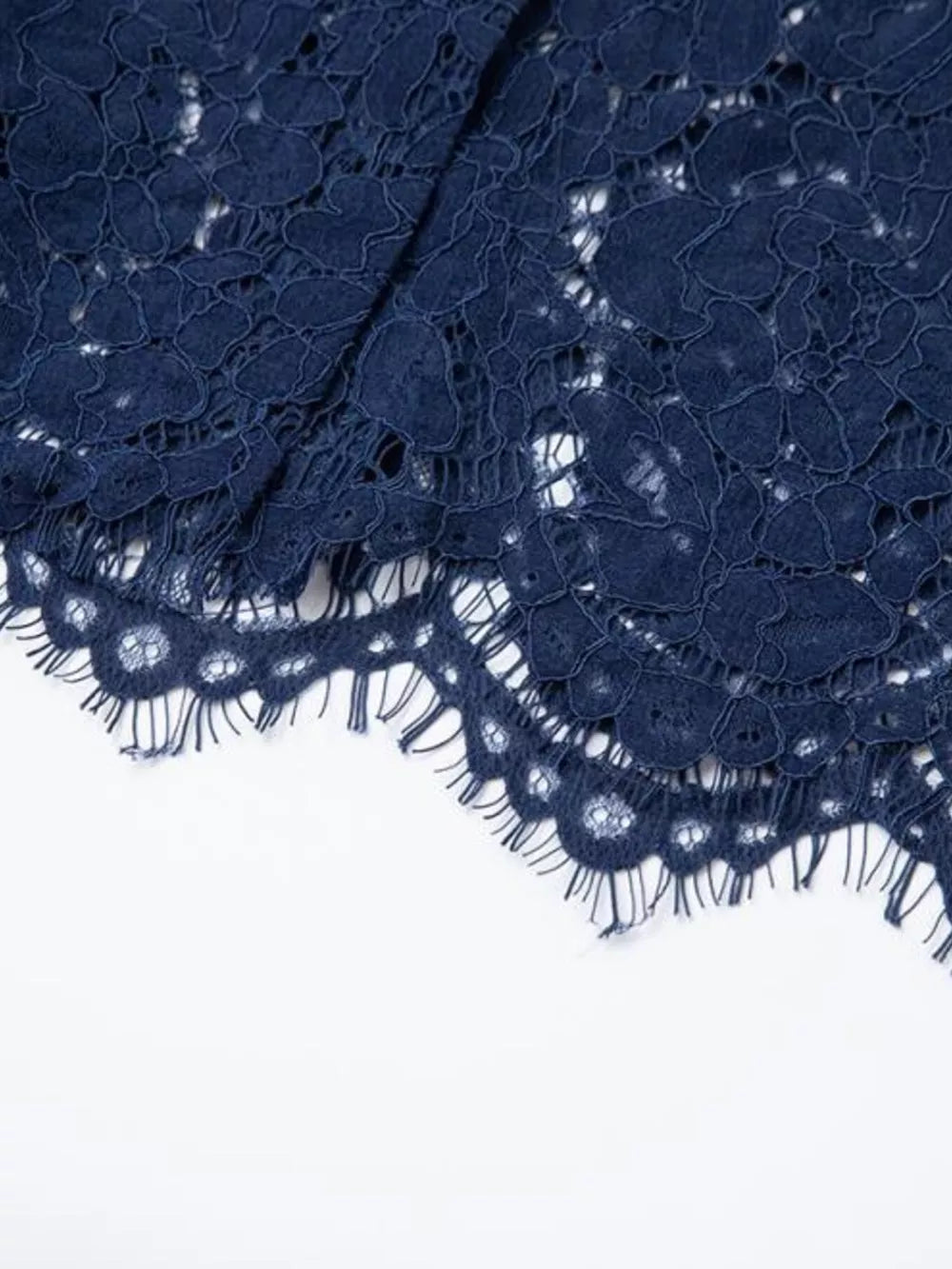 Navy lace midi dress detail with scalloped hem and floral pattern.