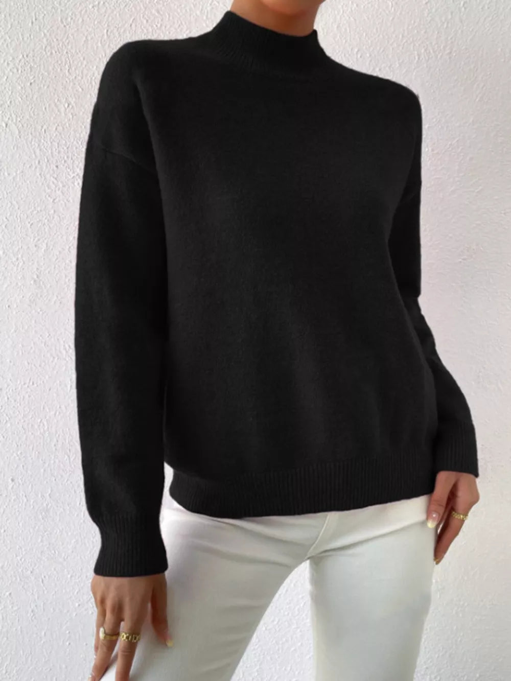 Black mock neck sweater with dropped shoulders, ribbed cuffs and hem.