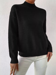 Black mock neck sweater with dropped shoulders, ribbed cuffs and hem.