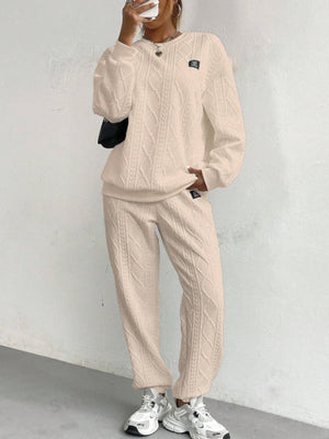 Tan cable knit loungewear set with crewneck sweatshirt and jogger pants.