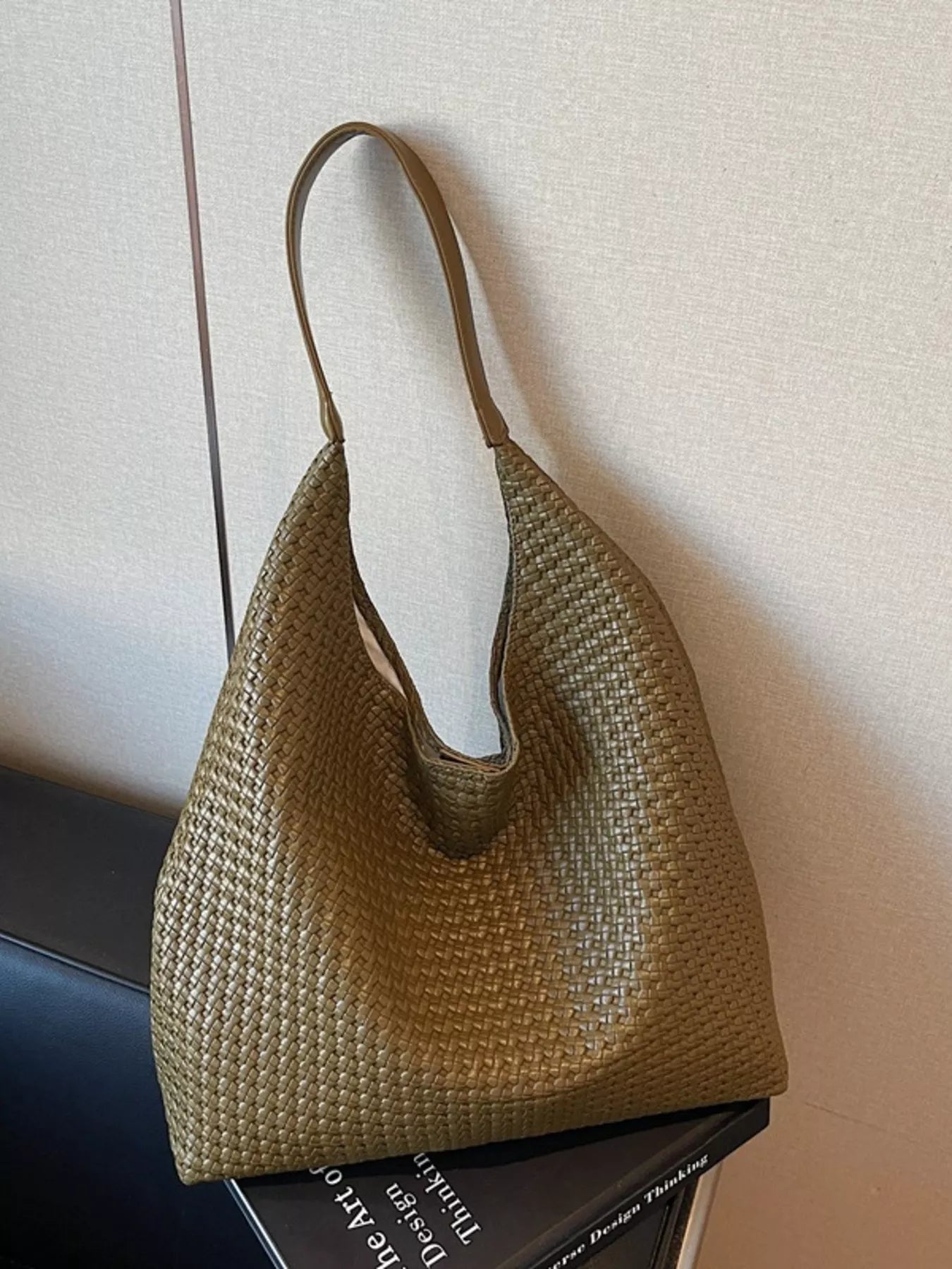 Green woven straw tote bag with a textured finish and single strap.