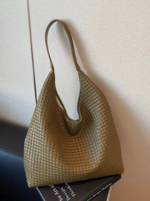 Green woven straw tote bag with a textured finish and single strap.