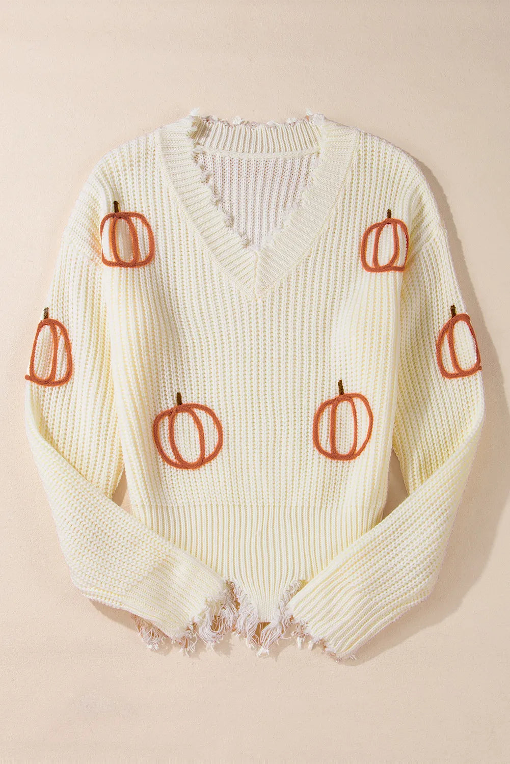 Beige distressed knit sweater with all-over pumpkin embroidery and frayed hem.