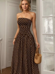 Brown polka dot strapless maxi dress with a cinched waist and full skirt.
