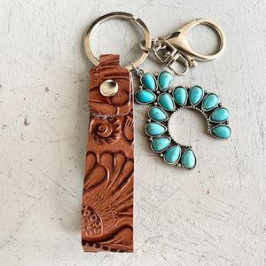 Tooled leather and turquoise horseshoe keychain with silver hardware.
