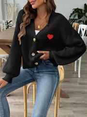 Black buttoned cardigan with balloon sleeves and red heart appliqué detail.