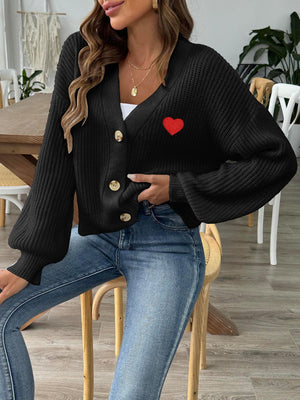 Black buttoned cardigan with balloon sleeves and red heart appliqué detail.