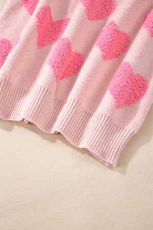 Blush pink knit sweater with textured heart motif and ribbed hem.