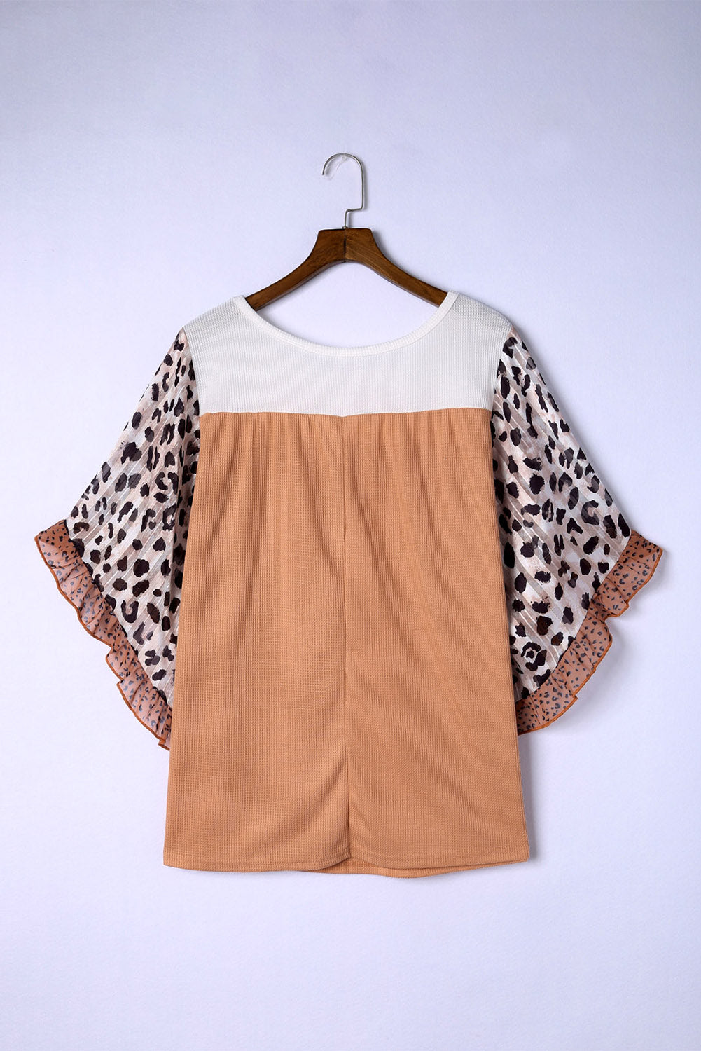 Colorblock waffle knit top with leopard print flutter sleeves and ruffled trim.