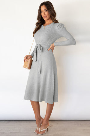 Light gray cable knit midi dress with self-tie belt and puff sleeves.