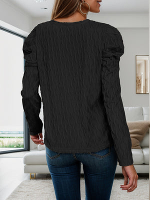 Black textured knit sweater with puff sleeves and a crew neck.