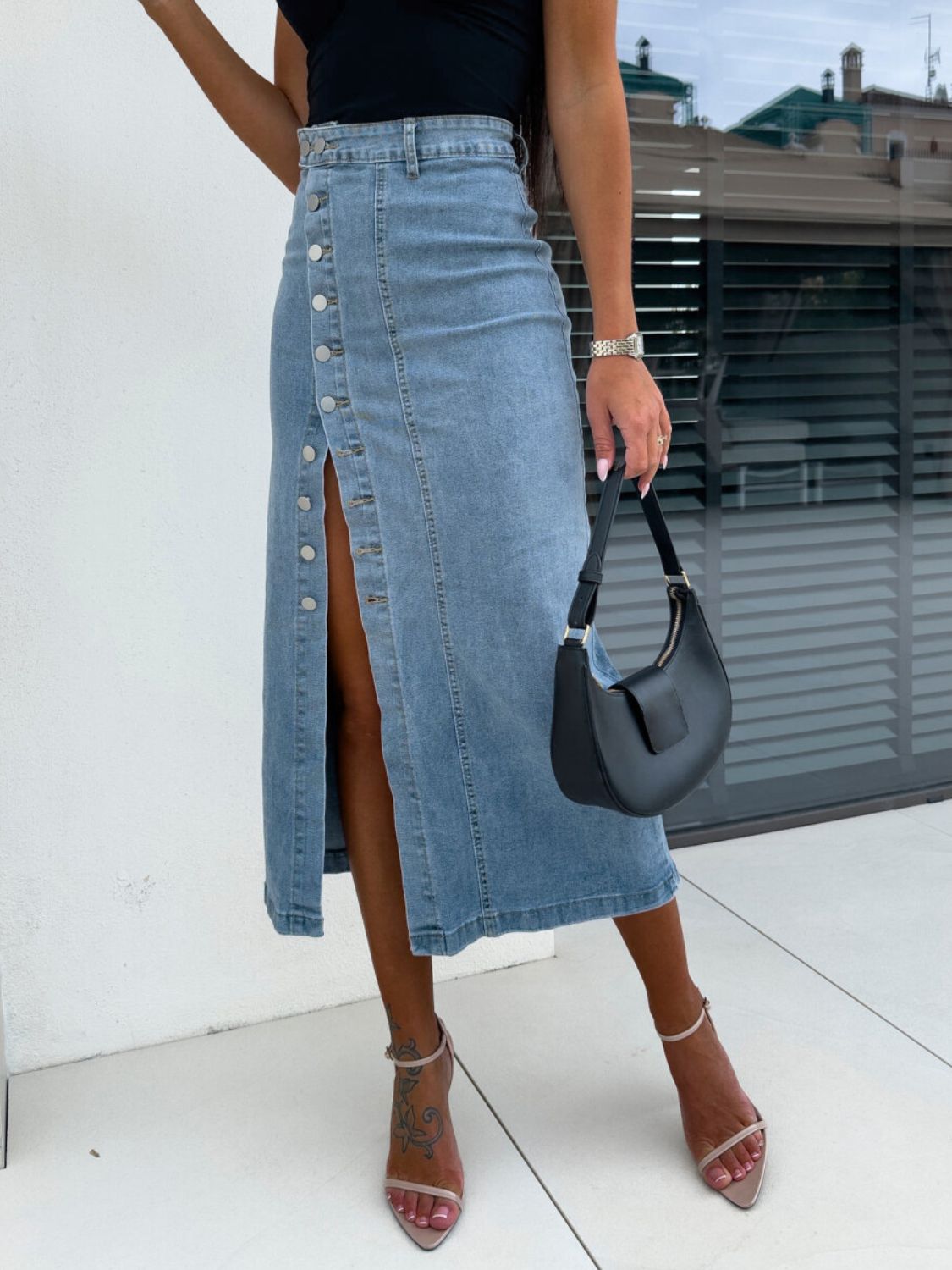 Button-front denim midi skirt in light wash with a high slit and silver buttons.