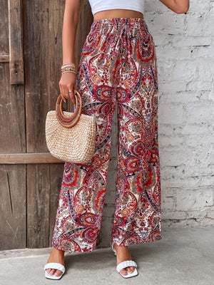 Paisley palazzo trousers with drawstring waist in multicolor, featuring a wide leg and boho print.