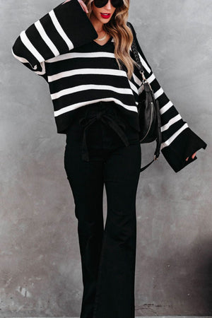 Black and white striped knit sweater with wide bell sleeves and a V-neck.