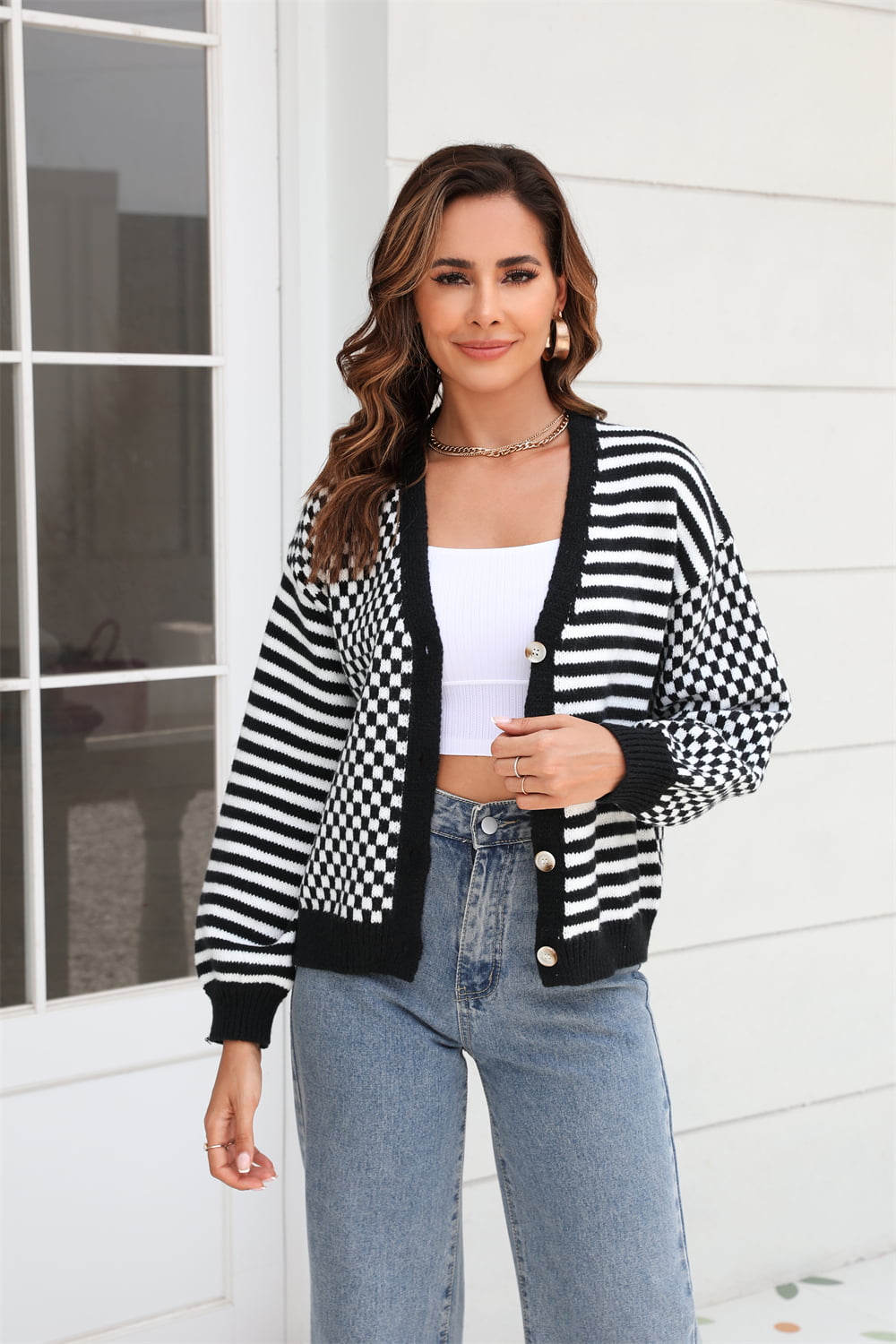 Black and white checkerboard sleeve contrast cardigan with button front and striped body.