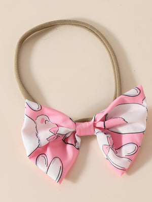 Pink baby headband with a bow featuring a whimsical bunny print.