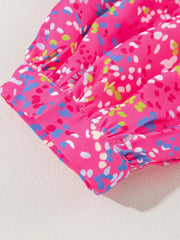 Hot pink blouse with a colorful abstract dot print and ruched mesh sleeves.