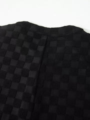 Black checkered wide-leg jumpsuit with button-front detail.
