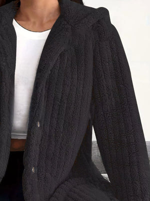 Black button-up fleece jacket with textured fabric and visible buttons.