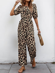 Leopard print jumpsuit with puff sleeves, tie neckline, and wide legs.