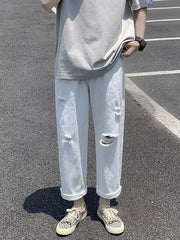 White distressed relaxed fit men's jeans with cuffed hems.