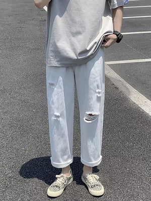 White distressed relaxed fit men's jeans with cuffed hems.