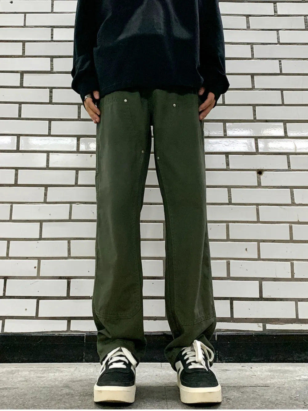 Army green relaxed fit cargo pants with utility details and silver button accents.