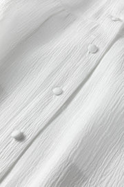 White crinkled texture button-down shirt with elastane, showing fabric detail and buttons.