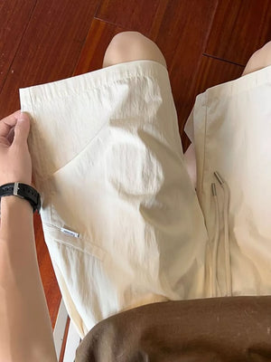 Men's relaxed fit drawstring shorts in beige with pocket detail and metal-tipped drawstrings.